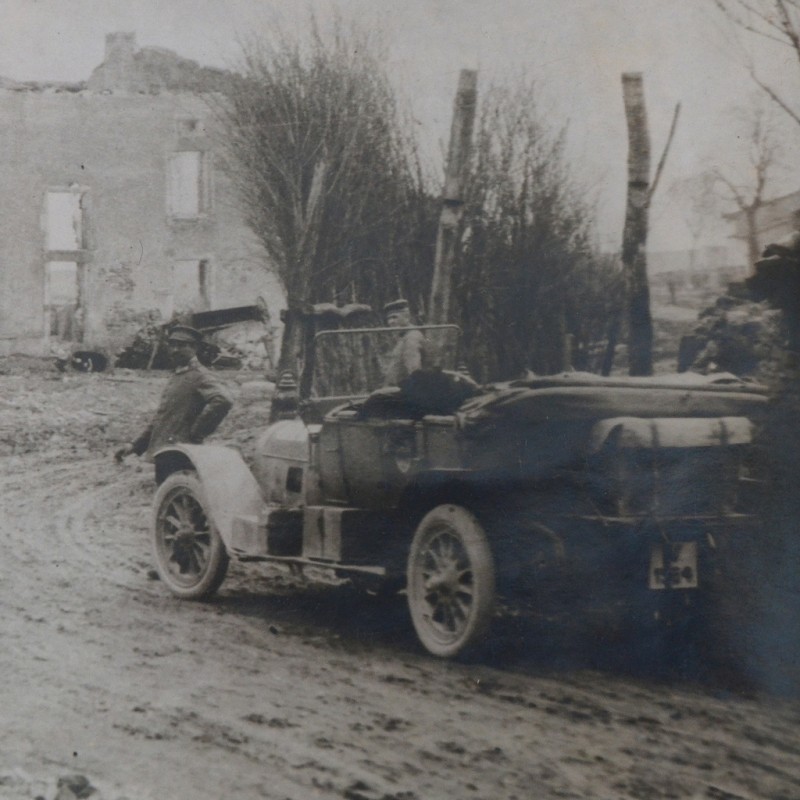 Large-format photo of a German car in front of a destroyed church