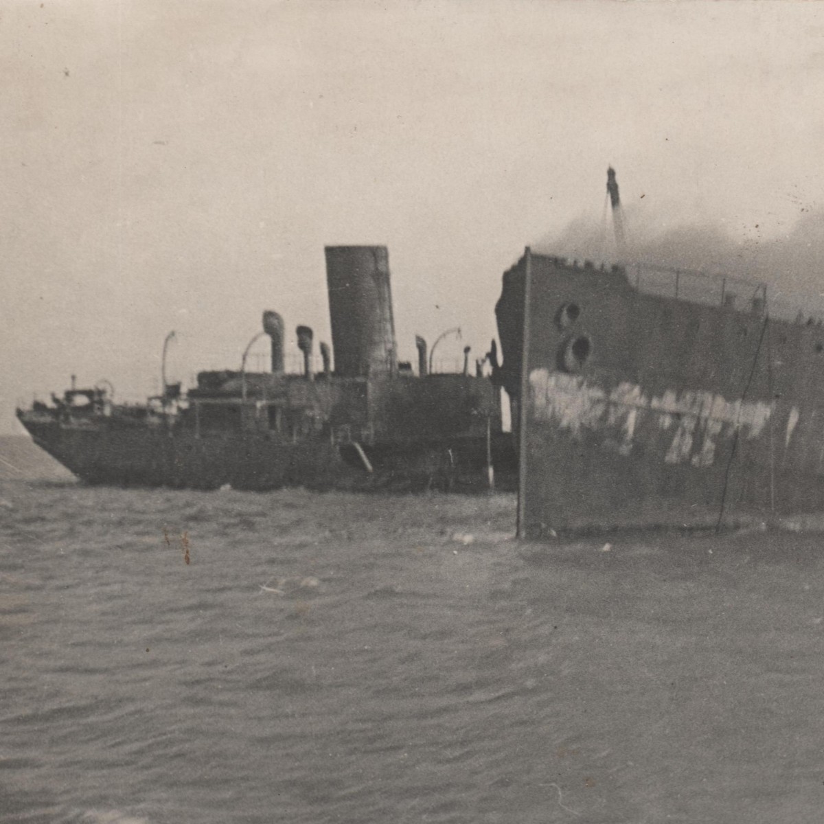 Photo of a partially sunken Soviet barge and boat