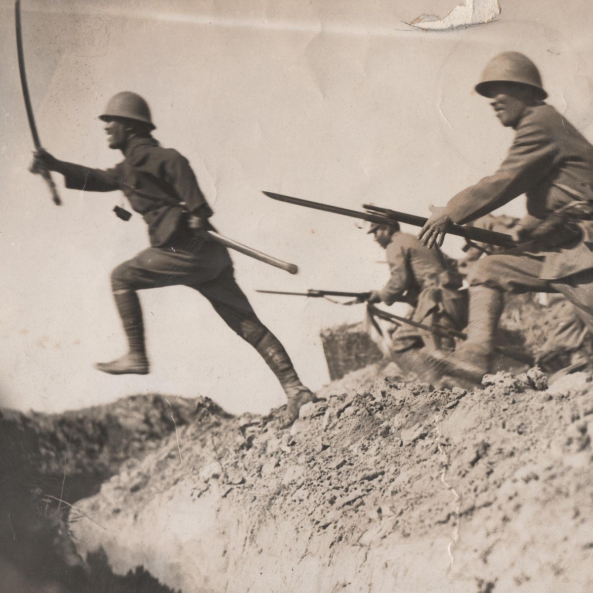 Press photo of Japanese soldiers and a sergeant rising to the attack
