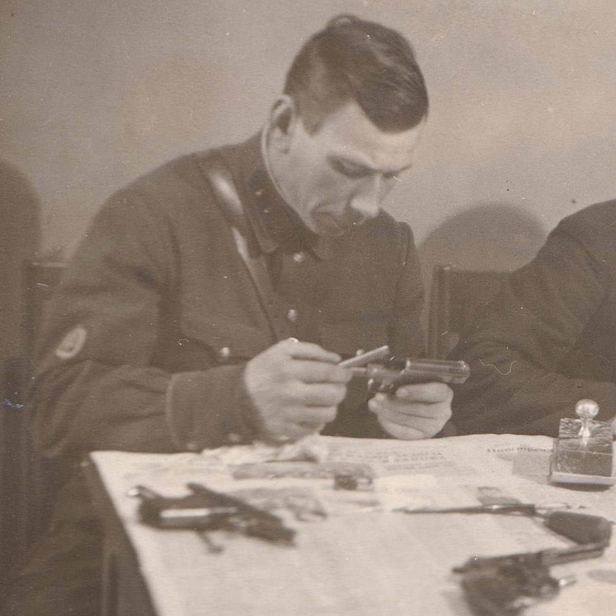 Photo of an employee of the GB NKVD cleaning pistols